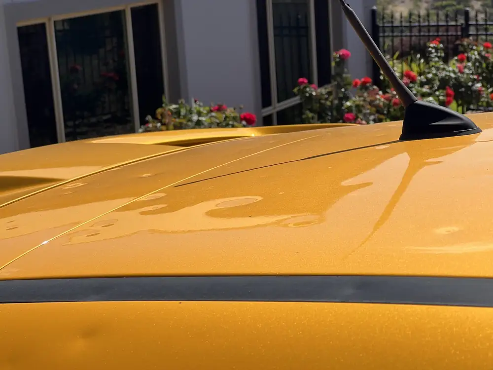 Hail dents on the roof of a gold car, before paintless dent repair